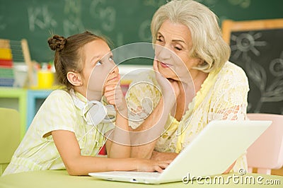 Portrait of grandmother and granddaughter using laptop Stock Photo