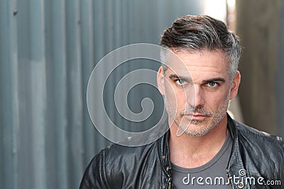 Close up portrait of gray haired bearded male dressed in a black leather jacket looking away Stock Photo