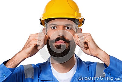 Close up portrait of handsome bearded builder in hard hat, foreman or repairman in the helmet playing with his moustache Stock Photo