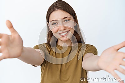 Close up portrait of happy girl hugging you, stretching out hands towards camera and smiling, reaching arms to hold Stock Photo