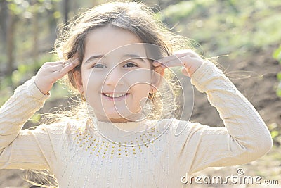 Close up portrait of a happy little girl at garden touching her hair in outdoor Stock Photo