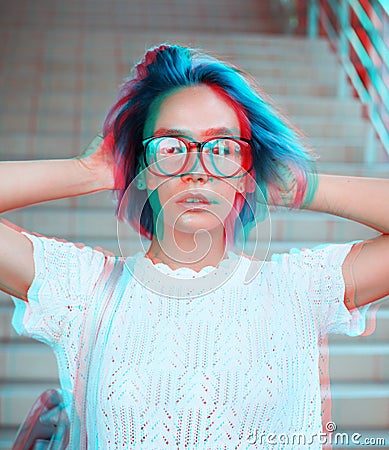 Close-up portrait of a hipster girl wearing glasses with blue hair. Atypical beauty. Street fashion Stock Photo