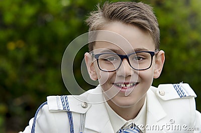 Close up portrait of a indented boy with glasses wearing a white sailor suit for his first communion Stock Photo