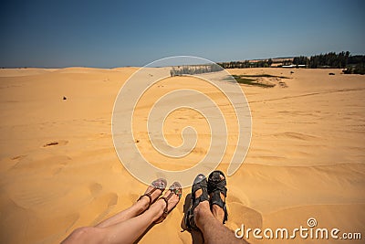 Close up portrait of legs, legs of couples lying with a mixture of golden sand dunes.Feet of a man and a woman in Stock Photo