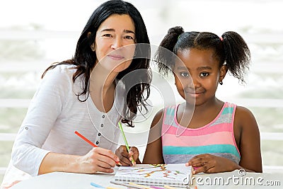 Little african girl and teacher drawing together. Stock Photo