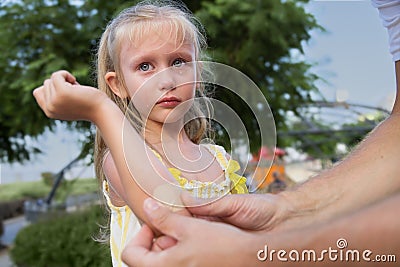 Little girl. Elbow wound. fell in the park on a walk, shows a wound and cries Stock Photo