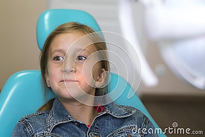 Close up portrait of a little smiling girl at dentist office. Dentist examining little girl's teeth in clinic. people, medicine, Stock Photo