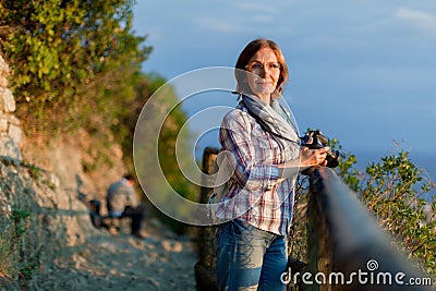 Close up portrait of lovely middle aged woman with dslr photo camera. Attractive thoughtful mature woman leaning resting Stock Photo