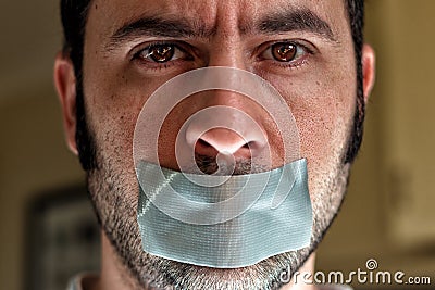Close up portrait of a man with duct tape over his mouth Stock Photo