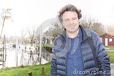 portrait of mature man smiling outside near port lake riverside Stock Photo