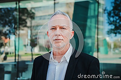 Close up portrait of a mature serious business man with aexecutive suit, gray hair, and successful attitude looking Stock Photo