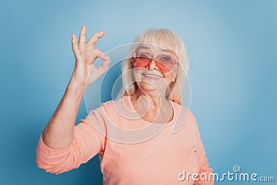 Close up portrait of pensioner promoter lady in sunglass show okey Stock Photo