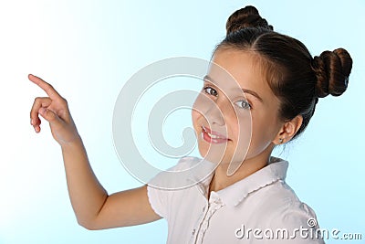 Close-up portrait of a pretty child girl smiles and points with her finger Stock Photo