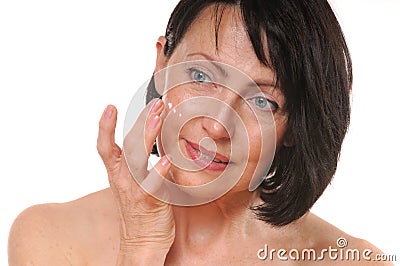 Close up portrait of pretty senior woman using face cream Stock Photo