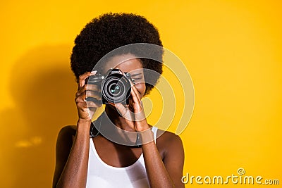 Close-up portrait of pretty wavy-haired brunette girl using digicam taking pictures snap isolated over bright yellow Stock Photo