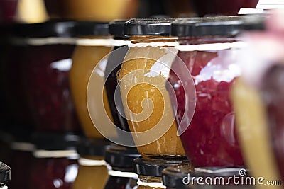 A close up portrait of rows of stacked glass pots with a metal black lid on them, with colorfull contents. Stock Photo