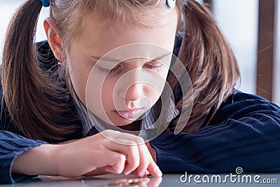 Close up portrait of sad and depressed business child girl counts coins. Concept of money, business, inflation and financial Stock Photo