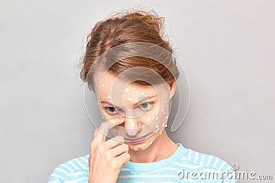 Portrait of sad tearful girl with white drops of face cream on skin Stock Photo