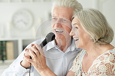 Close up portrait of senior couple singing karaoke Stock Photo