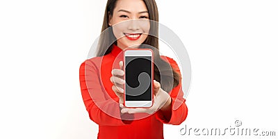 Close up portrait of a smiling asian woman showing blank screen mobile phone while standing isolated over white backgrou Stock Photo