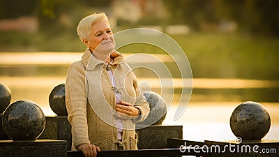 Close up portrait smiling attractive benevolent woman of retirement age. Calm brooding mature lady in casual clothes Stock Photo
