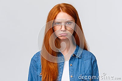 Close-up portrait strict and angry, mad gloomy redhead girl staring offended and disappointed, pouting frowning outraged Stock Photo