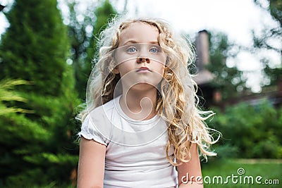 Close-up portrait of thoughtful little girl with long blond hair Stock Photo