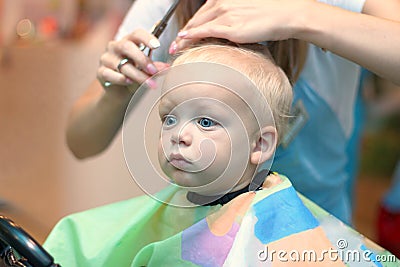 Close up portrait of toddler child getting his first haircut Stock Photo