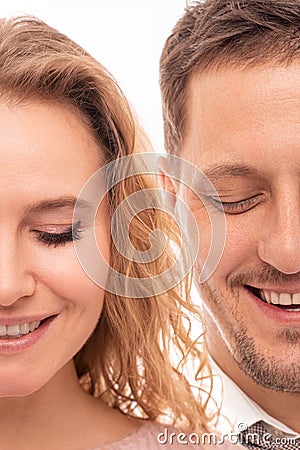 Close up portrait of two halves of face a positive smiling man and woman with closed eyes on white background. Halfface Stock Photo