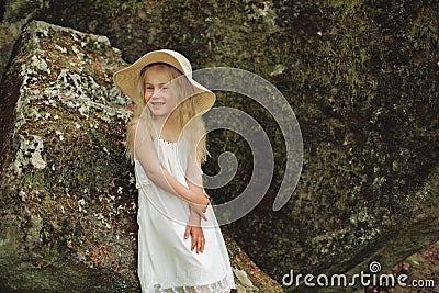 Close up portrait Ukrainian 7 year old girl seat on stone in forest Stock Photo