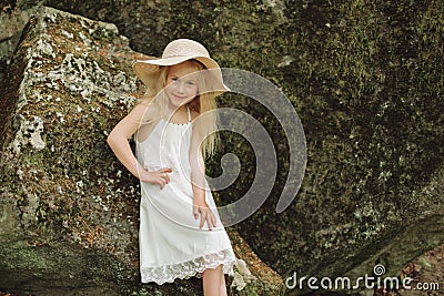 Close up portrait Ukrainian 7 year old girl seat on stone in forest Stock Photo