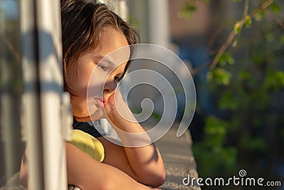 Close up of portrait upset little girl look far in window thinking about troubles, sad child Stock Photo