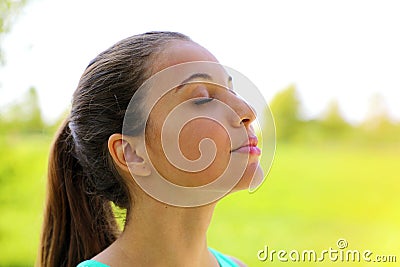 Close up portrait of woman relaxing breathing fresh air deeply in the park Stock Photo