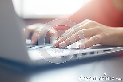 Close-up portrait of woman`s hands typing on laptop sitting at the table. Female businesswoman working on-line via laptop computer Stock Photo