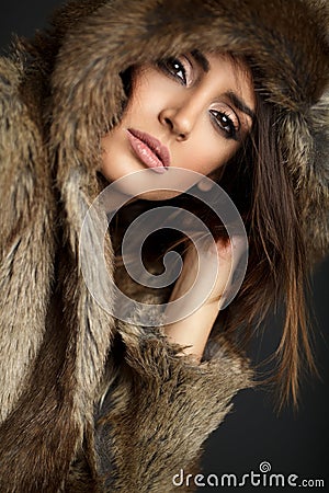 Close up portrait of woman wearing a fur coat posing in studio Stock Photo