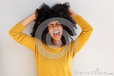 Close up young african girl screaming and pulling her hair against white background Stock Photo