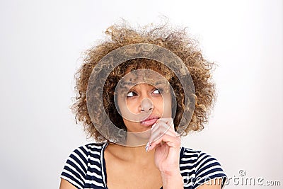 Close up young african woman thinking with hand on chin and and looking away Stock Photo