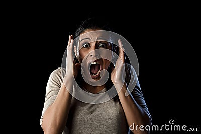 Close up portrait young attractive Latin woman screaming desperate screaming in primal fear emotion Stock Photo
