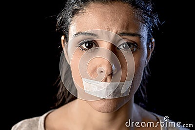 Close up portrait of young attractive woman with mouth and lips sealed in adhesive tape restrained Stock Photo