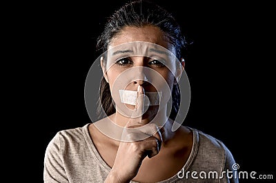 Close up portrait of young attractive woman with mouth and lips sealed in adhesive tape restrained Stock Photo