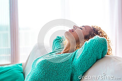 Close up and portrait of young beautiful curly woman relaxing and sleeping on the sofa or couch at home - vacations and free time Stock Photo