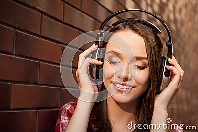 Close up portrait of young cheerful girl listening music with headphones Stock Photo