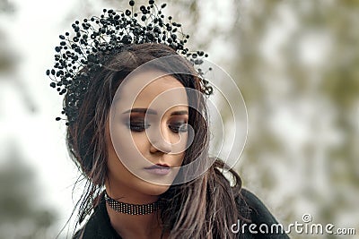 close up portrait of a young girl in the image of the black queen witch in a black crown tiara Stock Photo