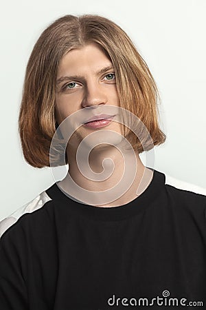 Close up portrait of young handsome guy with red ginger hear, slightly smiling, looking right to the camera. Wearing casual black Stock Photo