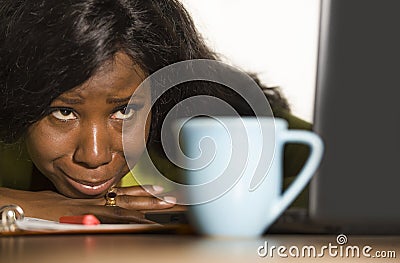 Close up portrait of young sad and depressed black afro American business woman crying while working at office computer desk feeli Stock Photo