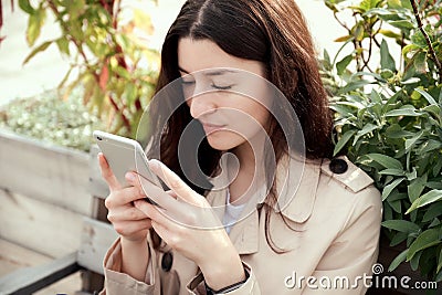 Close up portrait of young woman holding smartphone in her hands Stock Photo