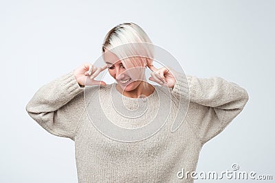 Close up portrait of young woman plugging ears with fingers. Stock Photo
