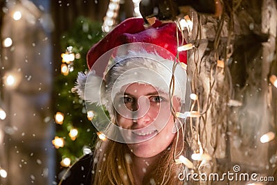 Close up portrait of young woman who look at camera, with santa Stock Photo