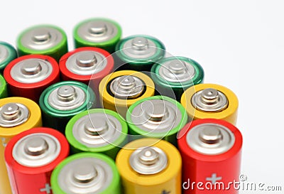 Different colours of batteries on white background. Close up of positive ends batteries, selective focus. Used battery for Stock Photo