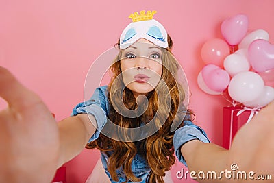 Close-up postrait lovely birthday girl posing in the morning with balloons and gifts behind her. Charming curly young Stock Photo